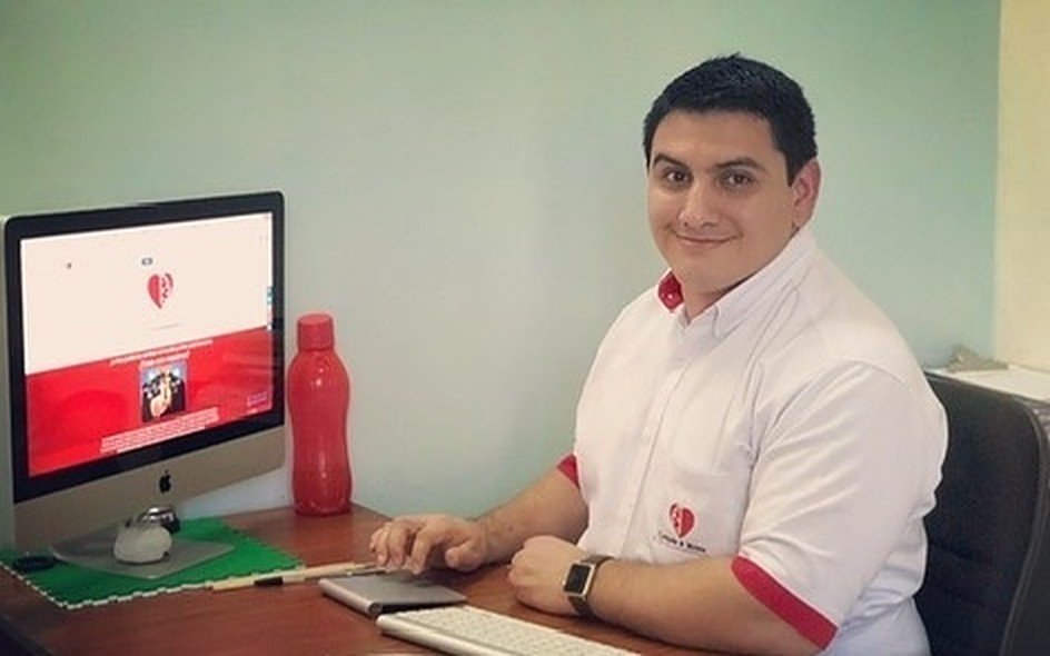 Stanley Gallegos, creador de Corazón y Mente, trabajando en su escritorio frente al sitio de la clínica